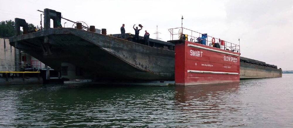 Barge lifted only partly in a red floating dock