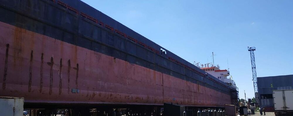 Side of a general cargo ship in a shipyard before lengthening